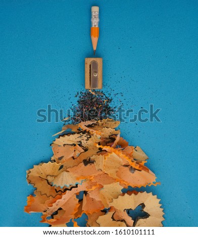 one small yellow Pencil with pencil shavings on blue paper background. Conceptual photo for various life situations. hard working idea. 