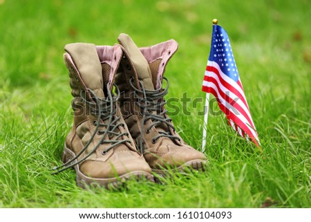 Military boots and USA flag outdoors. Memorial Day celebration