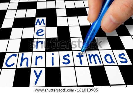 Hand filling in crossword - Merry Christmas - holiday concept