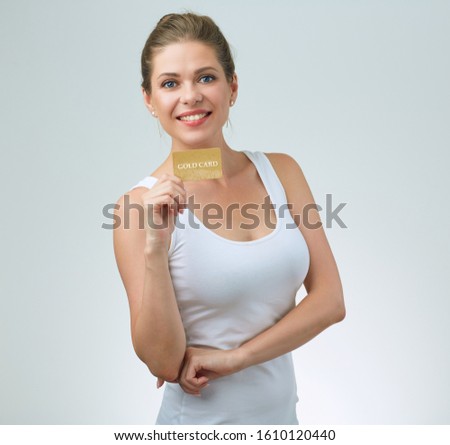 Happy woman in white sporty t shirt holding credit card. isolated female portrait.