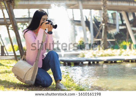 Young photographer taking photos outdoors.