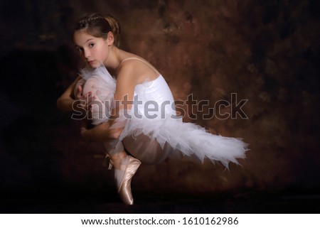 Little girl in a white dress and dance pointe shoes