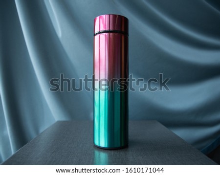 multicolored thermos on a black background