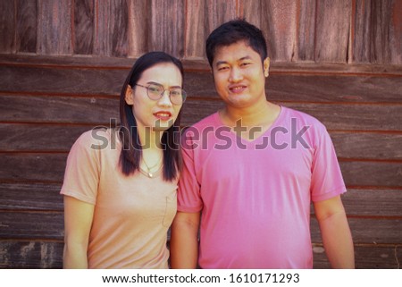 Couples who take pictures have wood background.