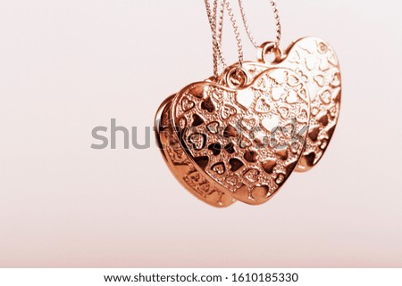 Heart on chain. Three golden hearts. Valentine's Day holiday. Golden hearts for boys and girls.
