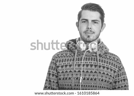 Young handsome Caucasian man wearing headphones around neck