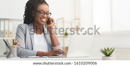 Lady Boss. Afro Businesswoman Talking On Cellphone While Working On Laptop In Modern Office, Wide Horizontal Banner, Panorama With Free Space