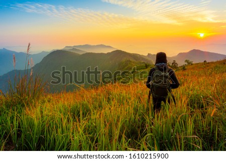 Man rest on mountain peak in background hills and clouds 