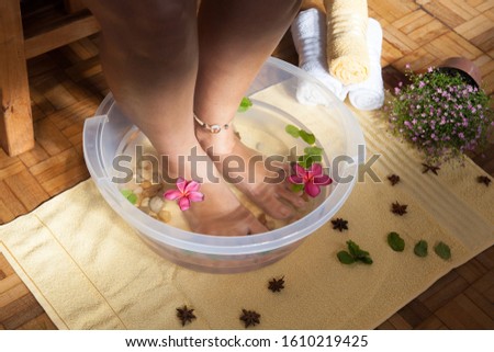 Scalding feet in bowl with water and yellow towel, flowers, star anise, mint. Good vibes Royalty-Free Stock Photo #1610219425