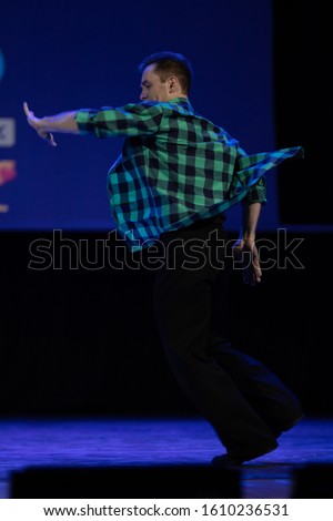 Actor dancer young man performs in the theater on stage in a retro dance musical show