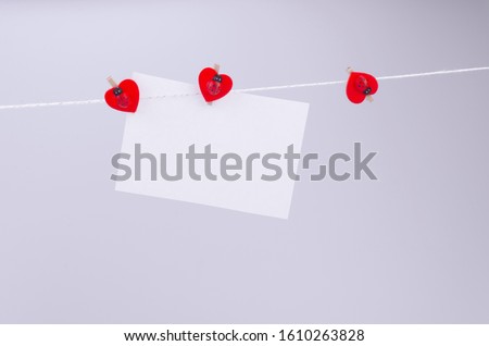 White sheet for notes and copy space on a thread with three red clothespins