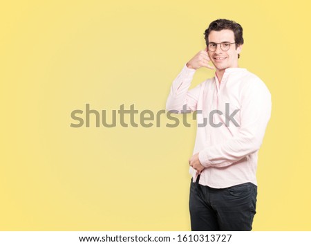 Happy young man making a gesture of calling with the hand