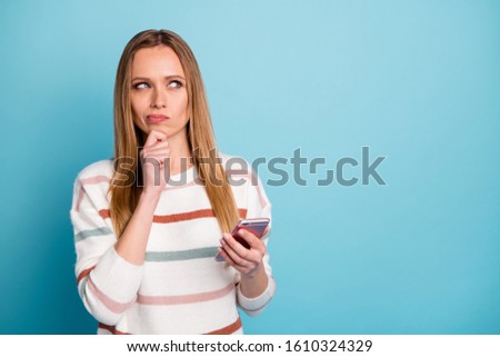 Photo of bewildered interested focused woman wearing striped sweater looking into empty space in search of creative ideas for presentation in her blog isolated pastel color background blue