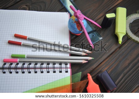 Office supplies are laid out on a wooden surface. View from above