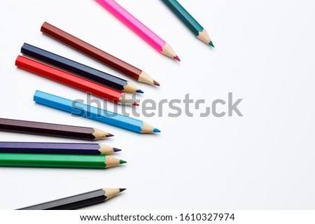 Color Pencils pointing to a target on white isolated background, for a powerpoint template or composition around school topics