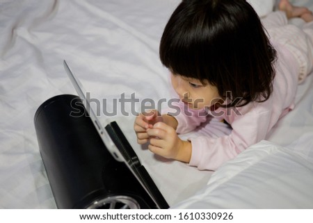 asian  chinese children watching tablet on bed
