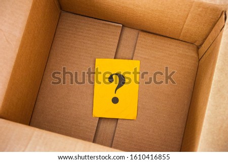 Question mark inside cardboard box. Close up.