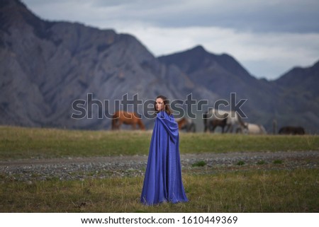 beautiful girl in a blue dress walks in the mountains