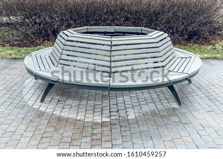 Modern round wooden bench in the park. Design of urban public space. The landscape park.
