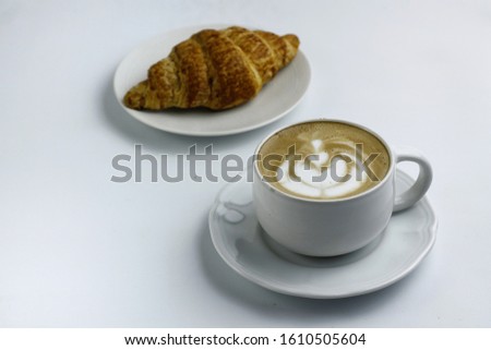 a cup of Latte coffee and one a croissant. with a white background, 