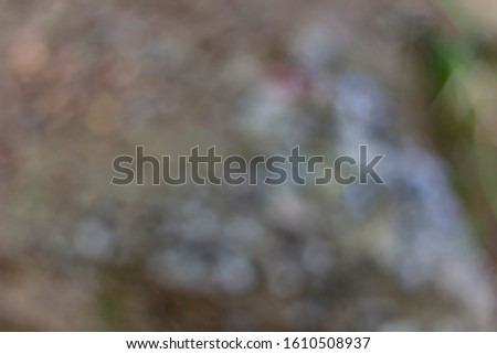 Colour Photography in the style of bokeh. Abstract photo is suitable for background. Blurred photographed on the ground gray stones and green grass