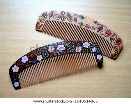 Two hand-painted wooden combs on the table.