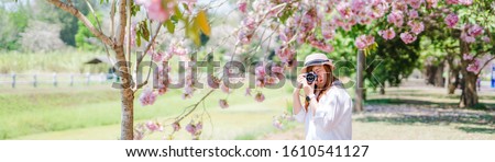 spring season with full bloom pink flower travel concept from beauty asian photographer woman enjoy with sight seeing and take photo  sakura or cherry blossom with soft focus flower background