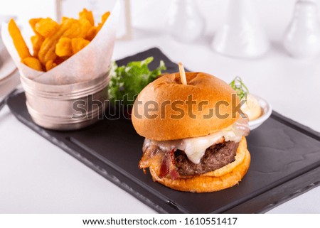 Burger with cheese and bacon, cutlet and fresh vegetables