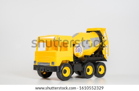 Plastic car. Toy model isolated on a white background. Yellow truck for the transport of building concrete.