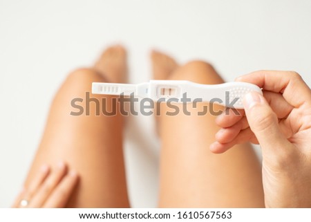 Top view of a woman holdin pregnancy test. Isolated on white