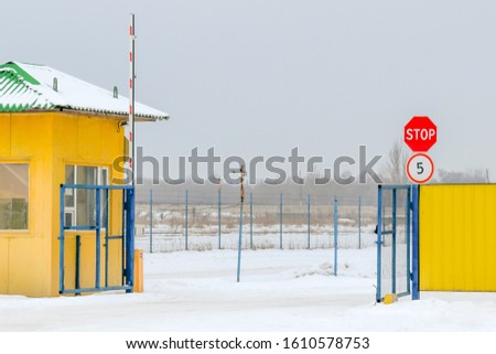 Entrance to the guarded territory, security checkpoint, raised barrier, stop sign and speed limit.