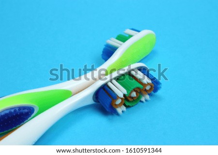 Two toothbrushes on a blue background
