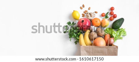 Healthy food background. Healthy vegan vegetarian food in paper bag vegetables and fruits on white, copy space, banner. Shopping food supermarket and clean vegan eating concept. Royalty-Free Stock Photo #1610617150