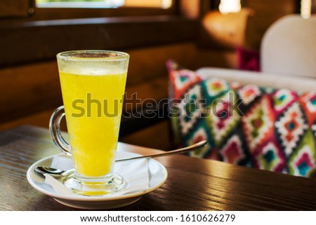 Vitaminic sea buckthorn tea in teaglass with fresh raw sea buckthorn berries. Traditional Autumn Drink in cafe