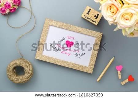 Mockup photo frame for Valentines day concept. Top view of mock up photoframe with rose flowers, craft roses and handy craft on grey home office desk table background.
