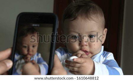 
Parent taking photo of baby with smartphone