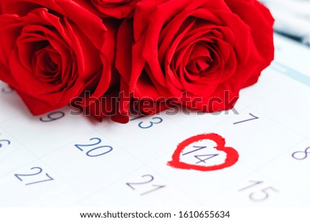 Open calendar February 2020 with the marked date with a heart on 14 Valentines day. Red roses on the calendar