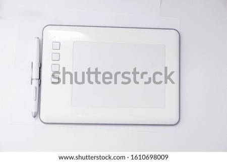 Modern white graphic tablet for drawing with a pen on a white background. Modern white graphic tablet for drawing with a pen.