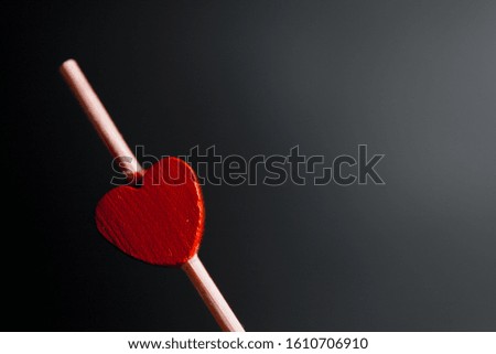 toothpicks with small red hearts on a black background. St. Valentine's Day