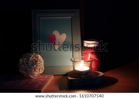 Blue frame with hearts, candles, straw ball and a jar of marmalade by candlelight, concept for Valentine's Day, wedding, birthday and other holidays, view from the top.