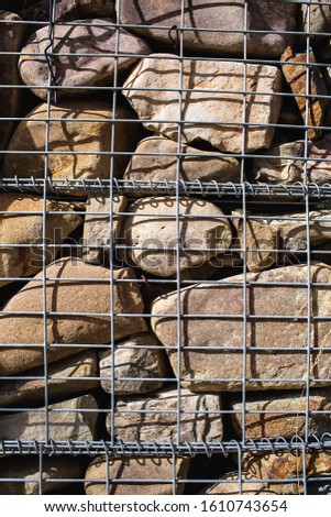 Gabions. Close-up of a steel mesh filled with large stones.