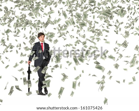 Businessman standing in the rain of money.
