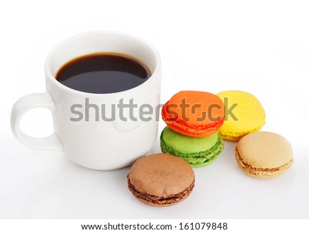 Delicious and colorful macaroons and a cup of black coffee on white