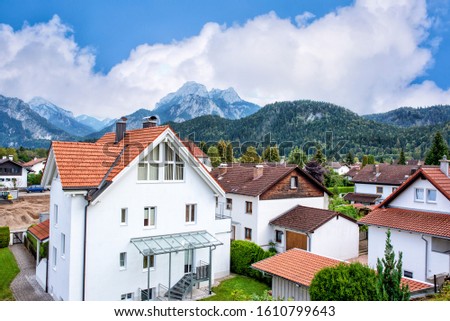 A great view of the Alps and an old German city in fall on background of mountains under blue sky.