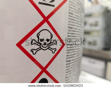 Label of a hazardous chemical in a scientific laboratory. Warning icons on toxicity and death.