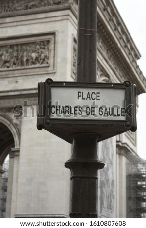 Place Charles De Gaulle sign close up with Arc De Triomphe in background