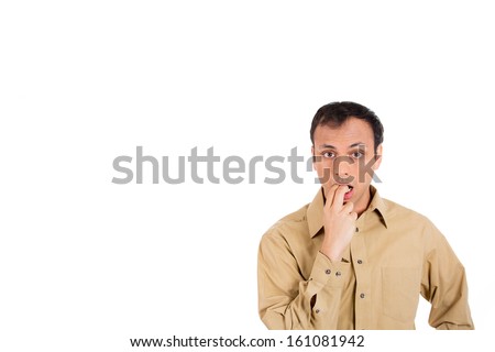 Closeup portrait of a scared surprised speechless handsome man in brown shirt with fingers in mouth, isolated on white background with copy space
