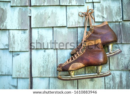 Vintage masculine leather ice skate  hanging on a green mint grunge wall
