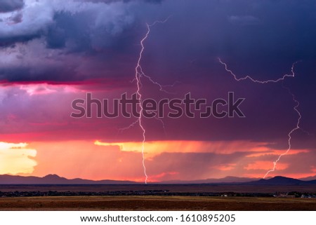 Thunderstorm lightning bolts with dramatic storm clouds at sunset