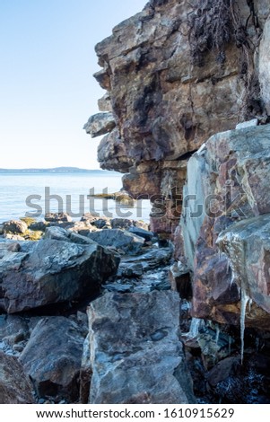 A rock along the coast with frozen water Royalty-Free Stock Photo #1610915629